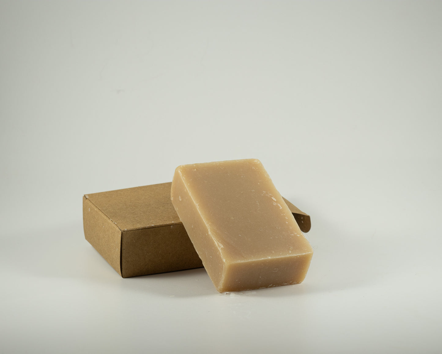 Handcrafted oatmeal, milk, and honey soap bar with a creamy natural finish, displayed with a kraft gift box for a soothing, luxurious bathing experience.