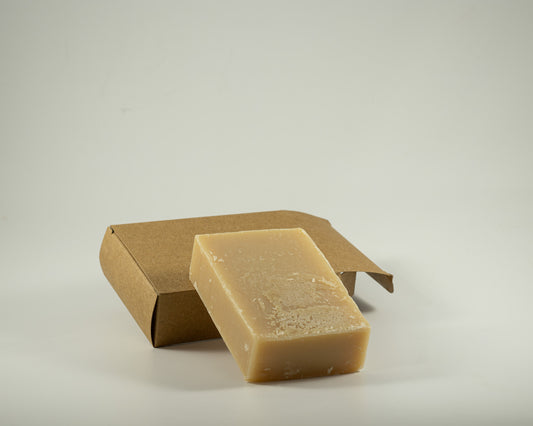 Handcrafted sandalwood soap bar with a creamy natural finish displayed beside a kraft gift box, thoughtfully selected for a relaxing gift experience.
