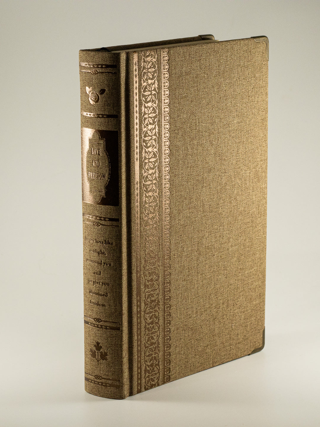 Vintage-inspired brown linen lined journal with embossed botanical spine and metallic detailing.