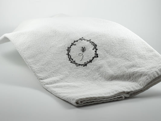 White textured kitchen towel with delicate black botanical illustrations.