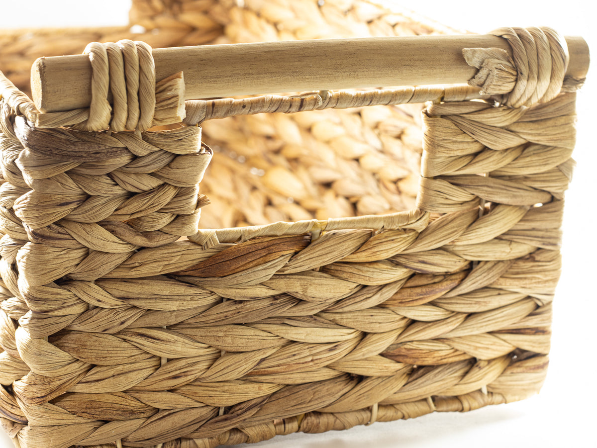 Close-up of a woven natural fiber gift basket and wooden handle to hold gift collection.