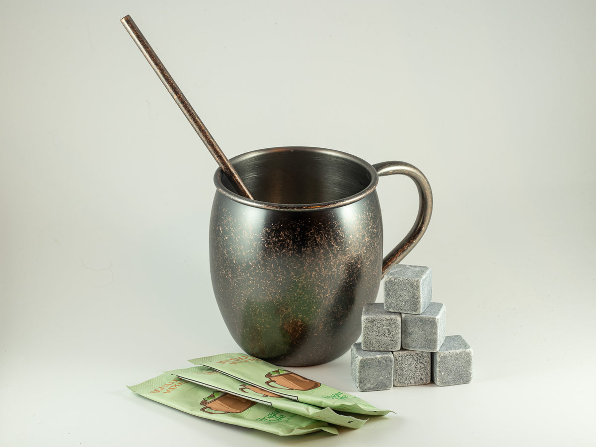 Copper mug with mule mix packets, metal stirrer, and whiskey stones